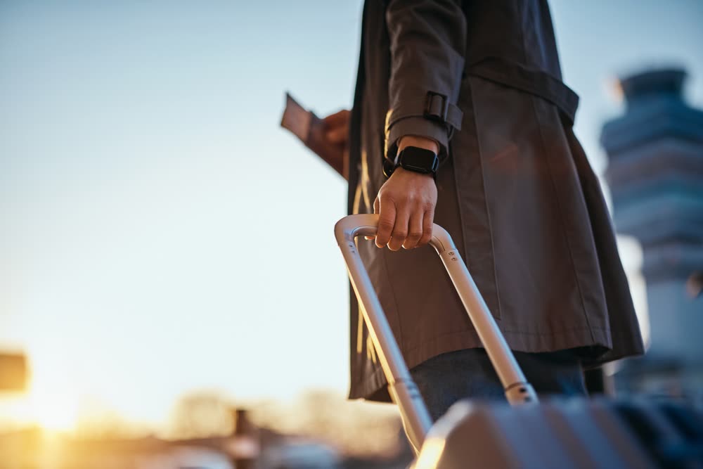Reiziger met koffer op weg naar de vertrekhal van Schiphol